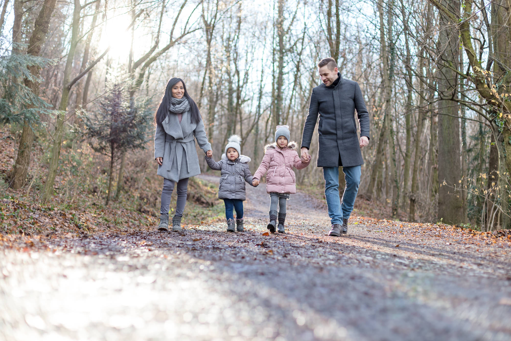 Mama Papa und 2 kleine Kinder spazieren im Wald bei Winter Fotoshooting in Graz