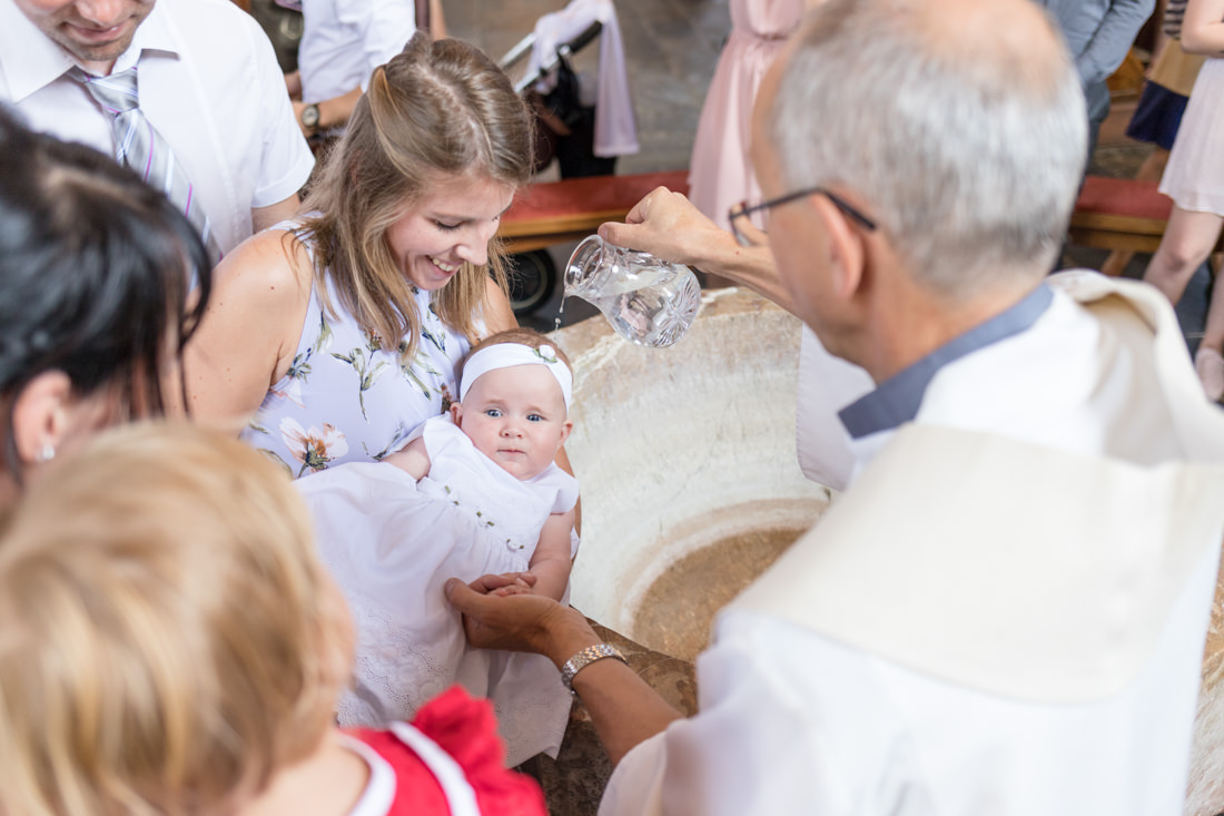 kleines Mädchen wird gerade getauft - Taufe Fotografin